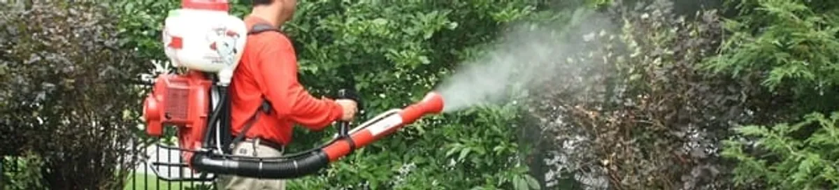Mosquito control technician fogging shrubs and landscaping for mosquito treatment in Portland, OR