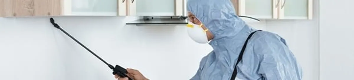 Termite treatment technician applying indoor pest control spray in Portland, OR